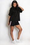 Woman wearing a black  Shorts outfit with white sneakers on a white background